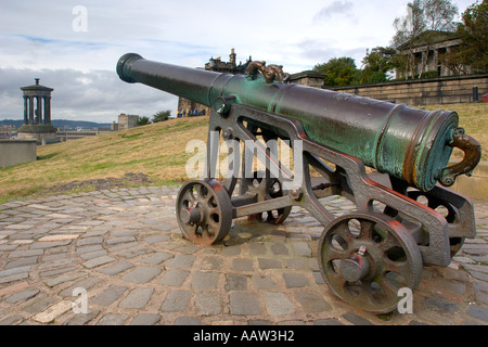 Cannon commémorative sur Calton Hill Edinburgh avec le Dugald Stewart Monument situé en face et une vue lointaine sur la ville Banque D'Images