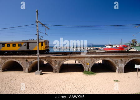 Un train en direction de passé sur le port de Kalk Bay Cape Town's littoral de l'océan Indien en Afrique du Sud. Banque D'Images