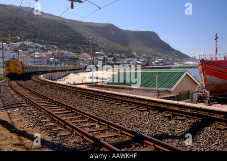 Un train en direction de passé sur le port de Kalk Bay Cape Town's littoral de l'océan Indien en Afrique du Sud. Banque D'Images