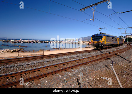 Un train en direction de passé sur le port de Kalk Bay Cape Town's littoral de l'océan Indien en Afrique du Sud. Banque D'Images