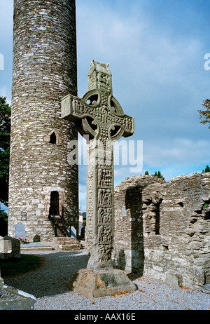 Un 10e siècle Christian sculpté croix de pierre à le site monastique de Monasterboice près de Drogheda En Irlande avec sa tour ronde Banque D'Images