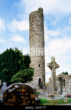 Un 10e siècle Christian sculpté croix de pierre à le site monastique de Monasterboice près de Drogheda En Irlande avec sa tour ronde Banque D'Images