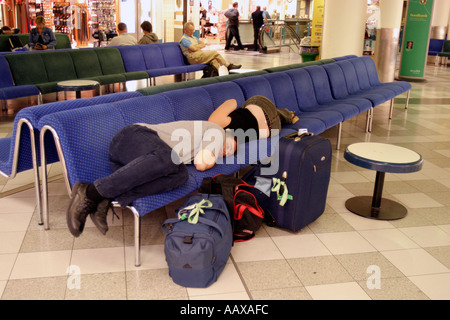 Les passagers endormis sur le sol à l'aéroport de Gatwick, en raison de retards des vols de vacances. Banque D'Images