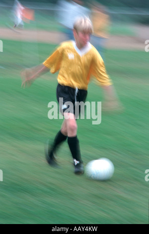 Soccer player Kicking the ball tout en jouant un jeu de football qui tentent de marquer un but à la verticale Banque D'Images