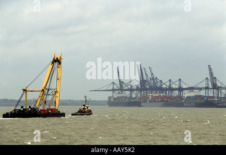 Remorqueur tractant une grue flottante dans le port de Felixstowe dans le Suffolk, le premier port de conteneurs. Banque D'Images