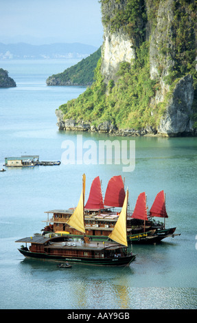 Bateaux de croisière jonque touristique avec voiles rouge et jaune, la baie d'Halong, Vietnam Banque D'Images