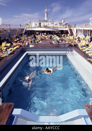 Les gens en vacances Thomson Emerald bateau de croisière de la piscine et jacuzzis au-delà de se détendre sur le pont de bain de soleil naviguant dans les Caraïbes tropicales Banque D'Images