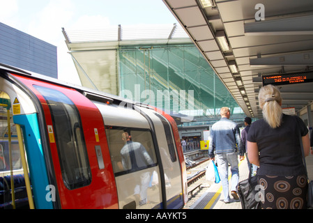 Un train de tube tire dans la station de métro Stratford et les gens marcher hors de Banque D'Images