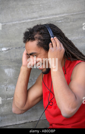 Jeune homme avec des dreadlocks à écouter de la musique Banque D'Images