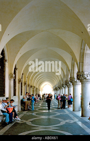 Le Colonnade voûtée à l'avant du Palais des Doges à Venise offre des sièges pour accueillir les touristes fatigués Banque D'Images