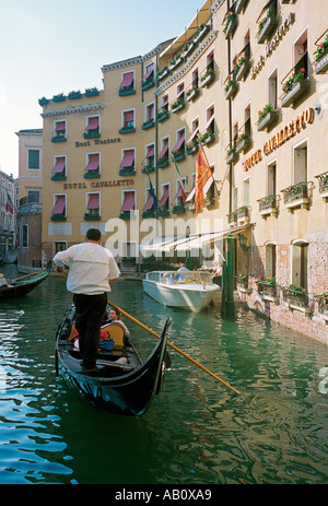 Un gondolier négocie son gondola le long d'un canal Vénitien Banque D'Images