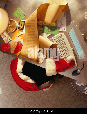 Vue de dessus d'un bureau où le Père Noël a été assis contrôler la liste de Noël de quitter l'ordinateur et la lumière sur Banque D'Images