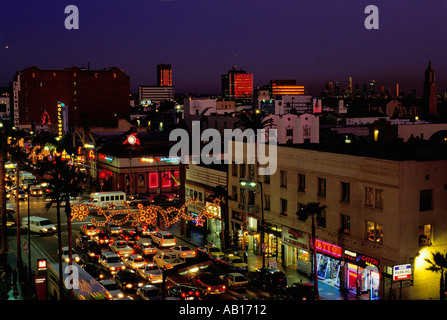 Scène de rue de nuit de Hollywood Blvd Highland St avec le centre-ville de Los Angeles dans l'arrière-plan Banque D'Images