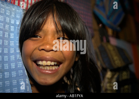 Smiling young girl peeks tissage entre l'affichage à l'Koho village minoritaire Dinh Lang ou un village près de Dalat Vietnam Poulet Banque D'Images