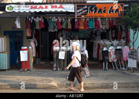 Visiteur passe devant l'une des nombreuses boutiques de tailleurs à Hoi An une ville historique milieu Vietnam Banque D'Images