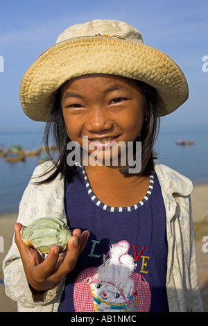 Jeune fille vendant des coquillages à Lang Chai, village de pêcheurs près de Mui Ne Vietnam Banque D'Images