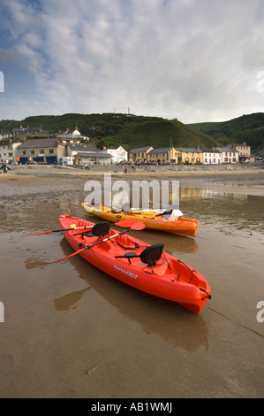 Canoës sur la plage de sable du village de Llangrannog Ceredigion Cardigan Bay West Wales UK , soirée d'été , à marée basse Banque D'Images