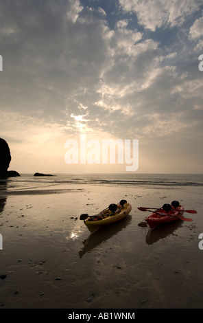 Deux canoës sur la plage au coucher du soleil de Llangrannog Ceredigion Cardigan Bay West Wales UK Banque D'Images