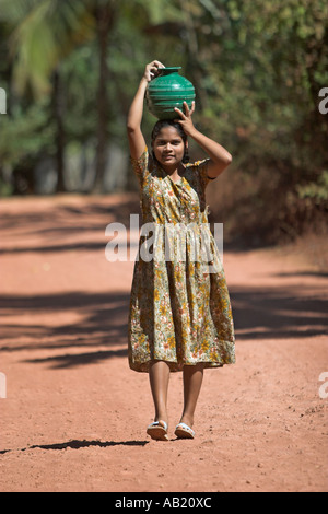 Jeune fille porte pot vert d'eau sur la tête de Goa Village Mandrem Banque D'Images