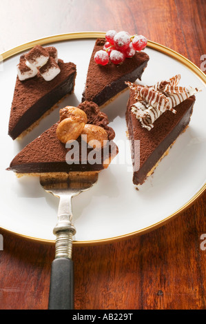 Quatre morceaux de tarte au chocolat avec différentes décorations FoodCollection Banque D'Images