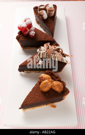 Quatre morceaux de tarte au chocolat avec différentes décorations FoodCollection Banque D'Images