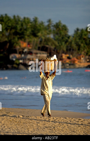 L'exercice du vendeur de plage panier tissé sur chef Goa Inde Banque D'Images