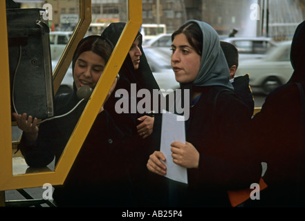 Les jeunes femmes en burqa à cabine téléphonique, Téhéran, Iran Banque D'Images
