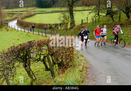 Groupe de marcheurs sur la route de campagne près de Llanwrtyd Wells Powys Pays de Galles UK prenant part à la vraie bière Ramble walking festival Banque D'Images