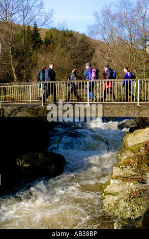 Les marcheurs qui prennent part à la real ale Ramble walking festival traverser la rivière Irfon flowimg rapide près de Llanwrtyd Wells Powys Pays de Galles Banque D'Images