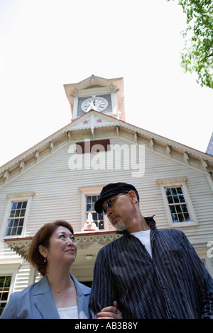 Senior couple standing in front of clock tower Banque D'Images