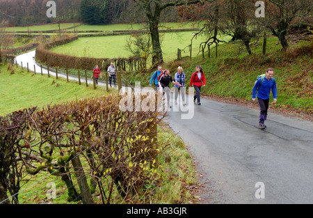 Groupe de marcheurs sur la route de campagne près de Llanwrtyd Wells Powys Pays de Galles UK prenant part à la vraie bière Ramble walking festival Banque D'Images