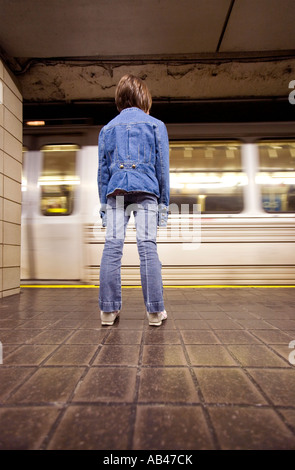 Une jeune fille se et attend qu'un métro Banque D'Images