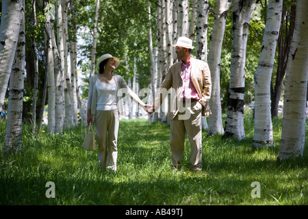 Mature couple walking in Silver Birch Grove Banque D'Images