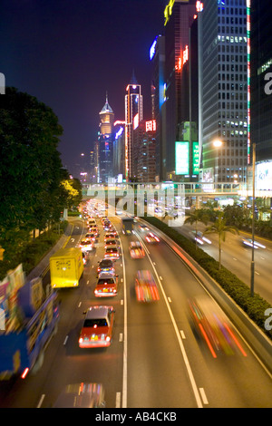 Une vue des gratte-ciel et le trafic avec effet de flou et de lumière le long des sentiers de la station de métro Gloucester Road sur l'île de Hong Kong dans la soirée Banque D'Images