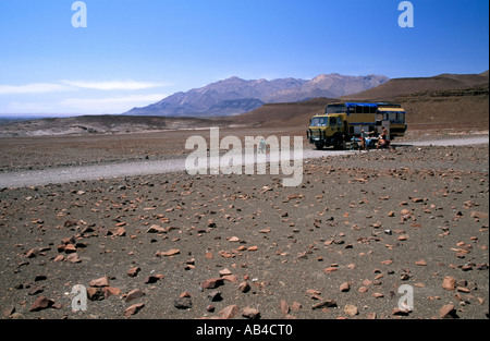 Les touristes sur un voyage par voie terrestre ayant une pause déjeuner sur une route isolée dans le désert de Namibie. Banque D'Images