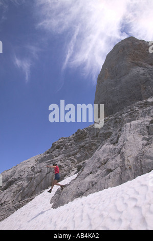 Les femmes sautant de roche en pente de neige ci-dessous Naranjo de Bulnes Parc National Picos de Eoropa espagne Banque D'Images