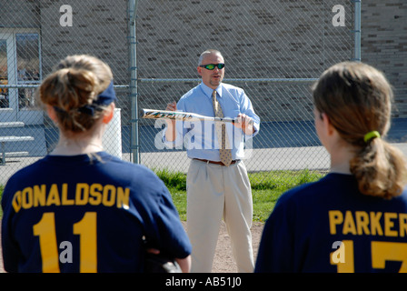 L'entraîneur de softball explique le concept de la balle à son bunting middle school girls softball team Banque D'Images