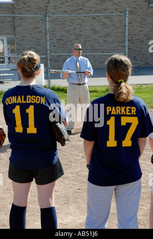 L'entraîneur de softball explique le concept de la balle à son bunting middle school girls softball team Banque D'Images
