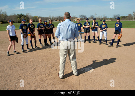 L'entraîneur de softball explique le concept de la balle à son bunting middle school girls softball team Banque D'Images