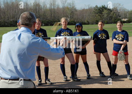 L'entraîneur de softball explique le concept de la balle à son bunting middle school girls softball team Banque D'Images