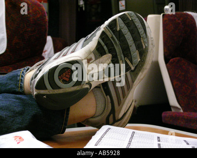 Passager de formateurs / sneakers met sur pieds table train Banque D'Images