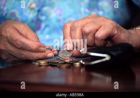 Femme âgée de 81 ans à compter de l'argent, Londres, Royaume-Uni. Banque D'Images