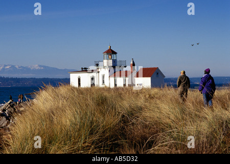 Les gens marcher dans les hautes herbes à West Point Light House USCG Discovery Park Seattle Washington Montagnes Olympiques Puget Sound Banque D'Images