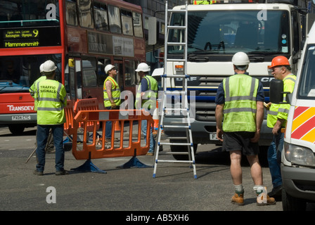 Les ouvriers qui ne travaillent pas autour d'attendre autour des feux de circulation dans la ville de Haymarket de Westminster travaille aux feux de circulation Londres Angleterre Royaume-Uni Banque D'Images