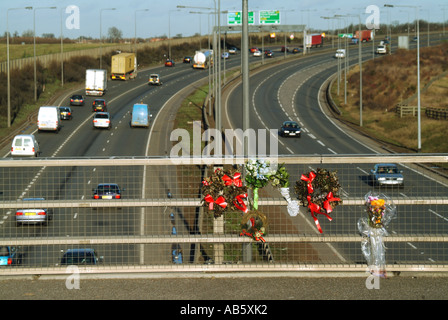 Essex tributs floraux placés sur le pont au-dessus du parapet garde-corps à deux voies à la suite d'un décès Banque D'Images