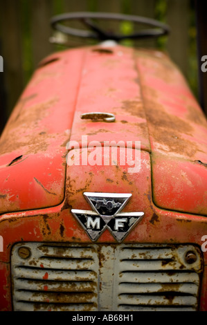 Vieux tracteur rouge Massey Ferguson en attente d'un nouveau propriétaire dans un garage en Llanfarian près d'Aberystwyth, Pays de Galles UK Banque D'Images