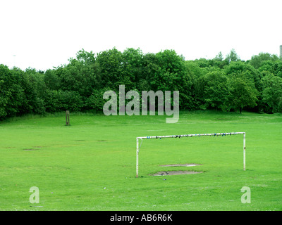 Delapated poteau de but en vert domaine de l'herbe et d'arbres Banque D'Images