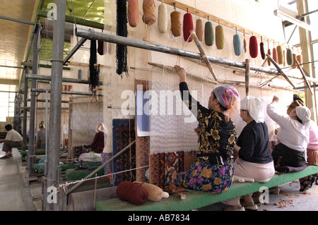 Les travailleurs Ouïghours musulmans femelle dans une fabrique de tapis traditionnels en Chine Xinjiang Hotan Banque D'Images