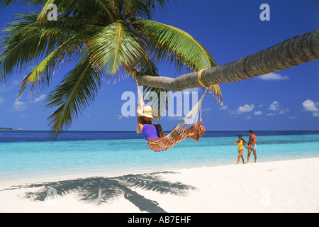 Femme en couple passant plus de hamac sur la plage pendant les vacances tropicales Banque D'Images
