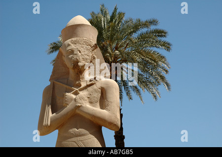 Statue de Ramsès II en granit avec palmier au Temple de Karnak en Egypte Banque D'Images